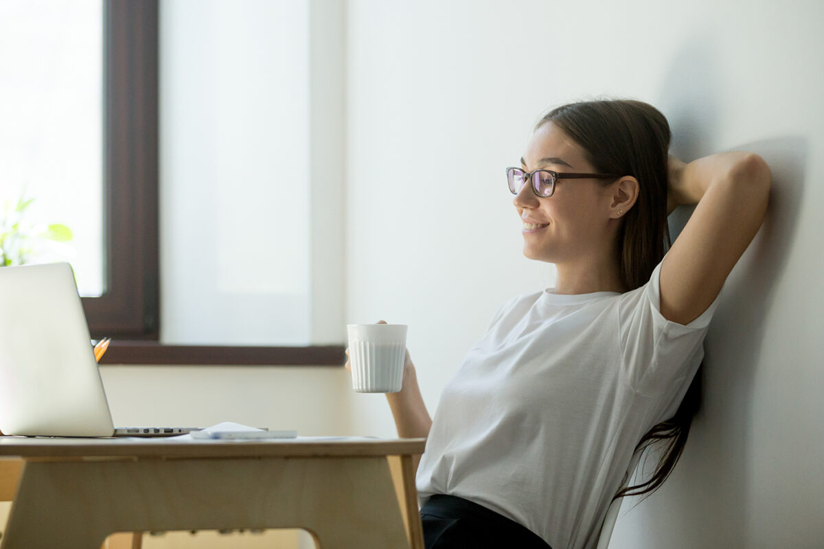 Satisfied female manager having break, resting and smiling looking at her computer.